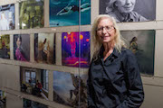 Annie Leibovitz standing in front of her photographs