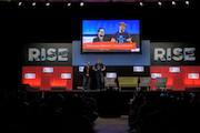 Two men on a stage during RISE conference 