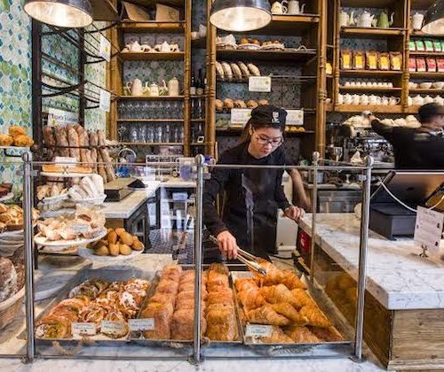 Woman serving bread at counter