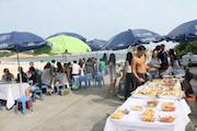 People eating from a buffet on a beach