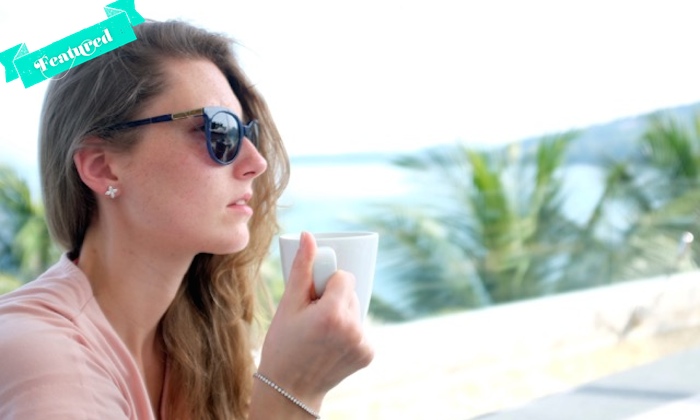 A woman with a coffee cup wearing a diamonds bracelet 