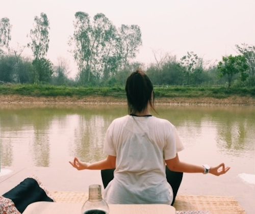 girl meditating on a lake
