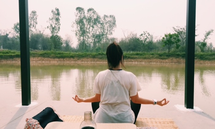 girl meditating on a lake