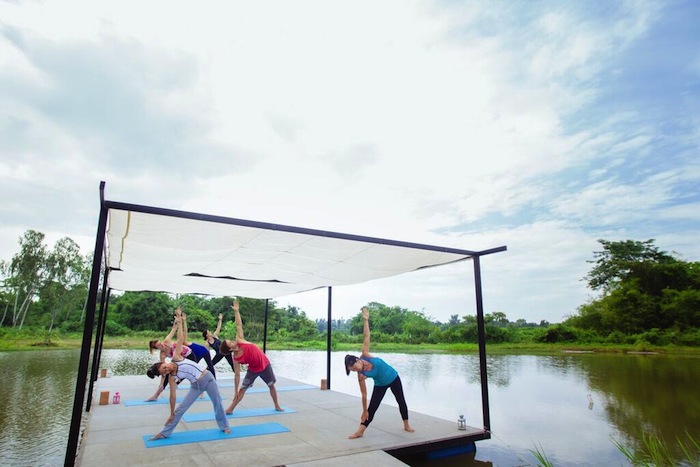 girls doing yoga on a floating platform