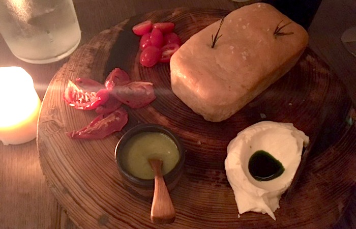 a board of bread cheese tomatoes and olive oil