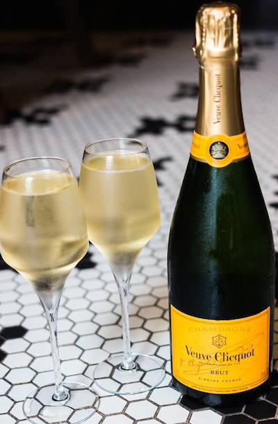 a bottle of verve champagne with two full glasses