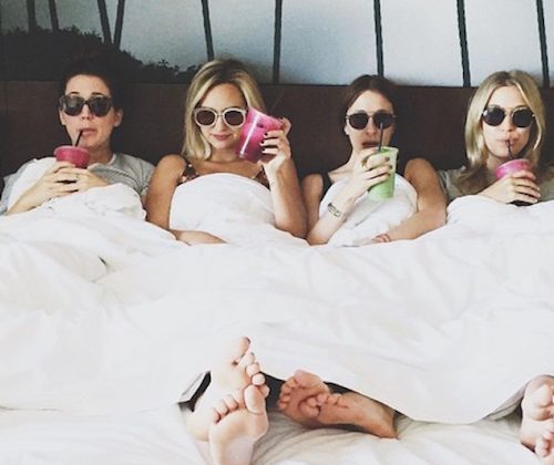 friends in a hotel room wearing sun glasses and drinking smoothies