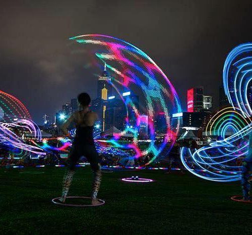 A woman spinning a fluorescent hula hoop
