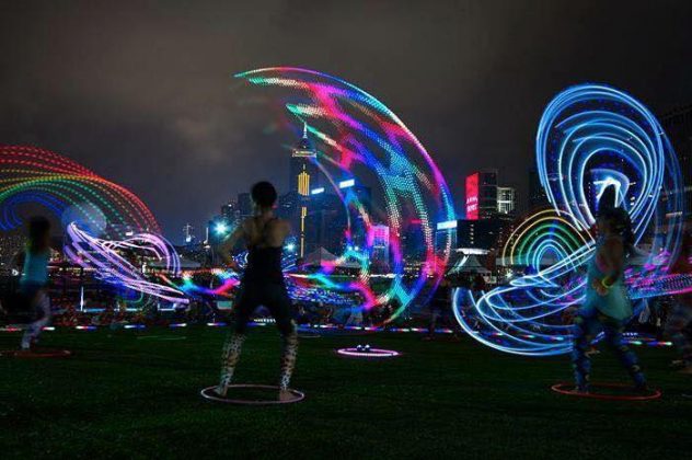A woman spinning a fluorescent hula hoop
