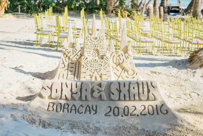 a sand sculpture with couples names carved in the sand