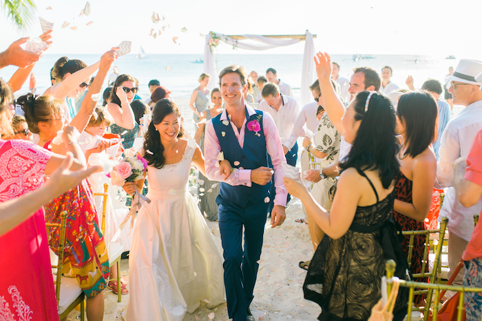 a newly wed couple walking through confetti