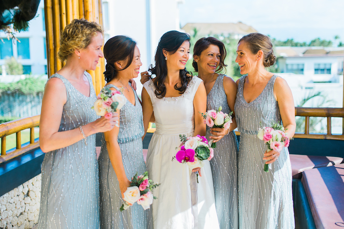 a bride and her bridesmaid holding colourful flowers