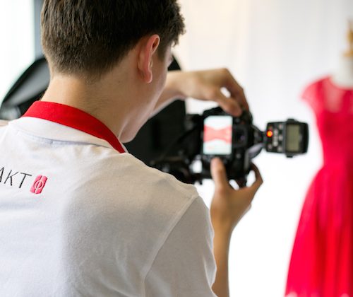man photographing a red dress