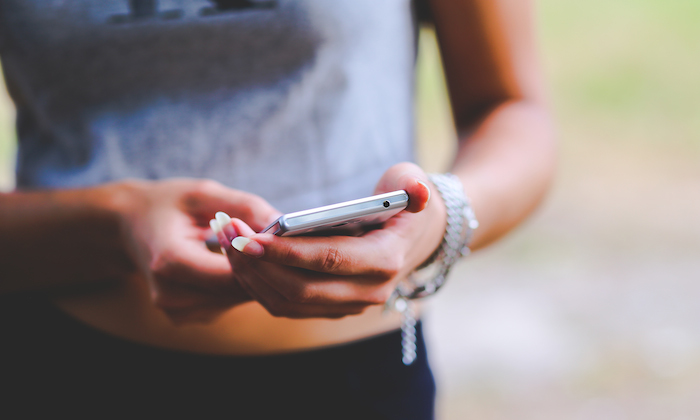 a girl in a grey tshirt on her phone