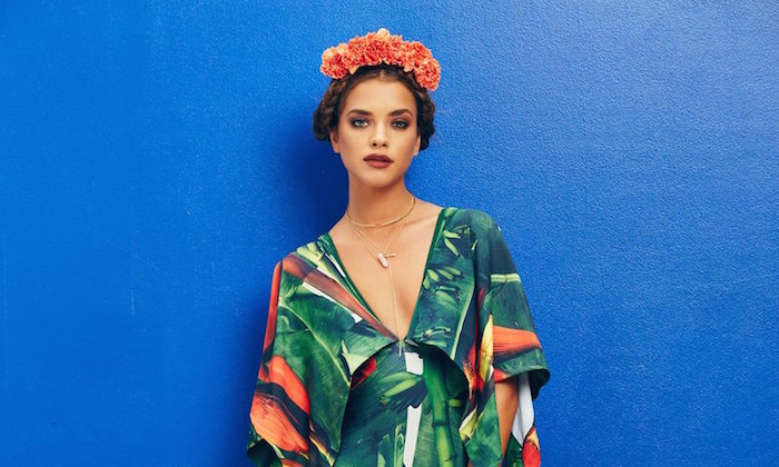 model in a tropical print dress wearing a flower crown