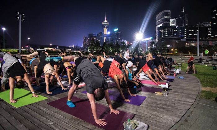 people doing yoga in front of the hong kong skyline