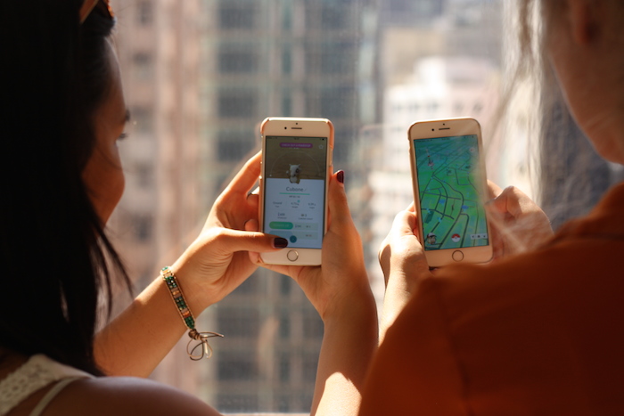 two girls playing pokemon go in hong kong