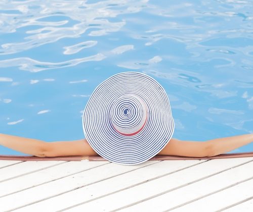 women in a swimming pool wearing a sun hat