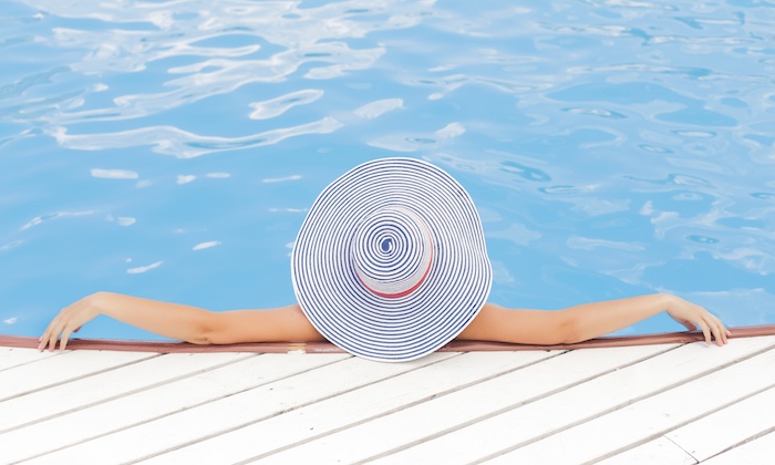 women in a swimming pool wearing a sun hat