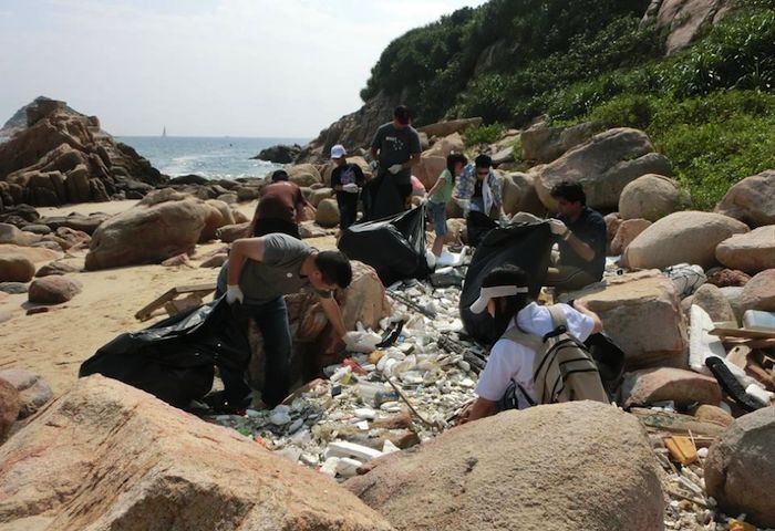 people cleaning up rubbish off rocks in hong kong