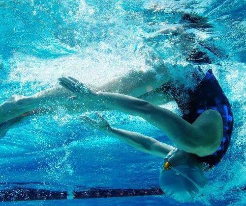 a girl doing a turn under water