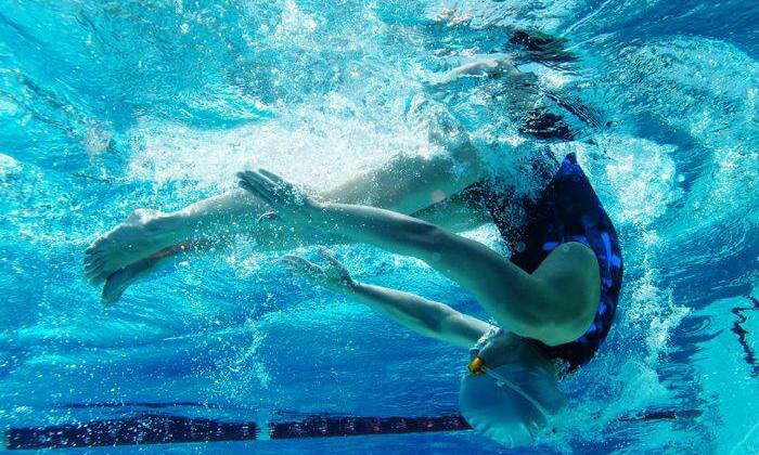 a girl doing a turn under water
