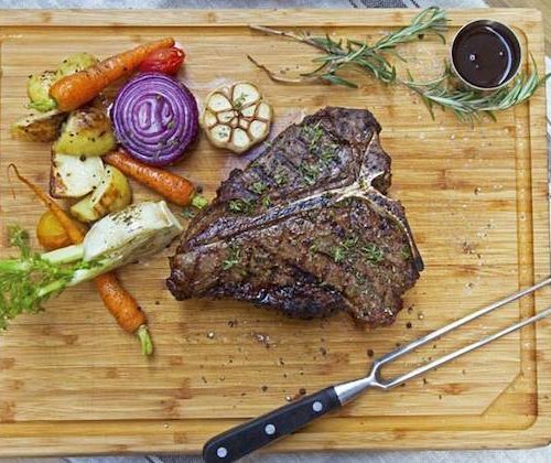 steak and vegetables on a wooden board