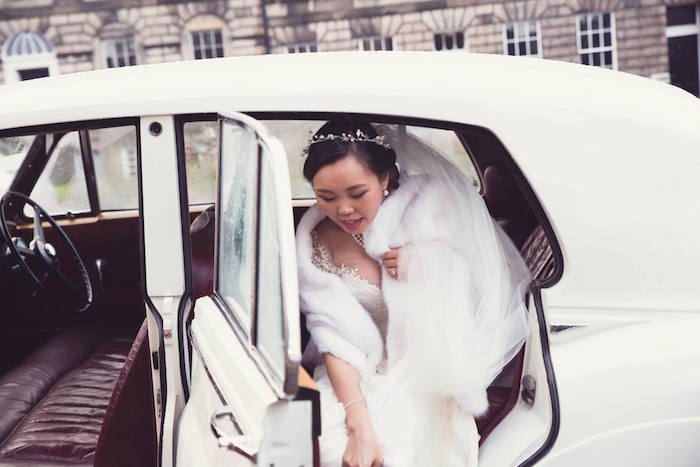 bride getting out of a white car