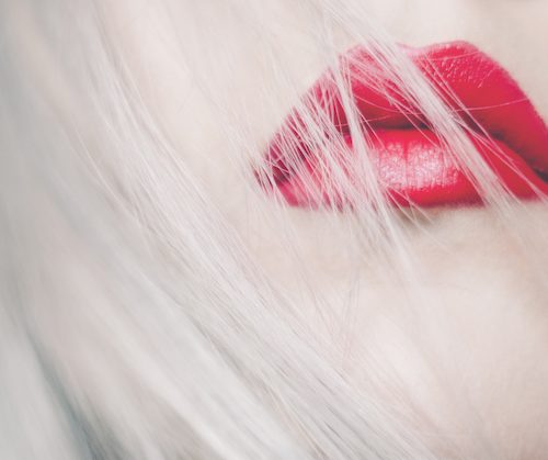 a woman with silver hair and red lips