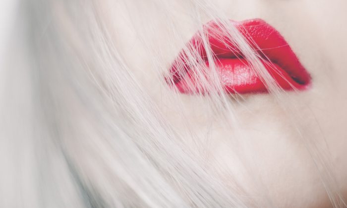 a woman with silver hair and red lips