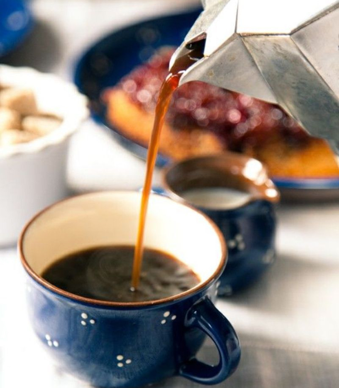 Pouring black coffee into a mug