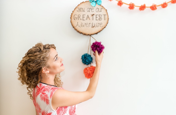 woman hanging wooden sign