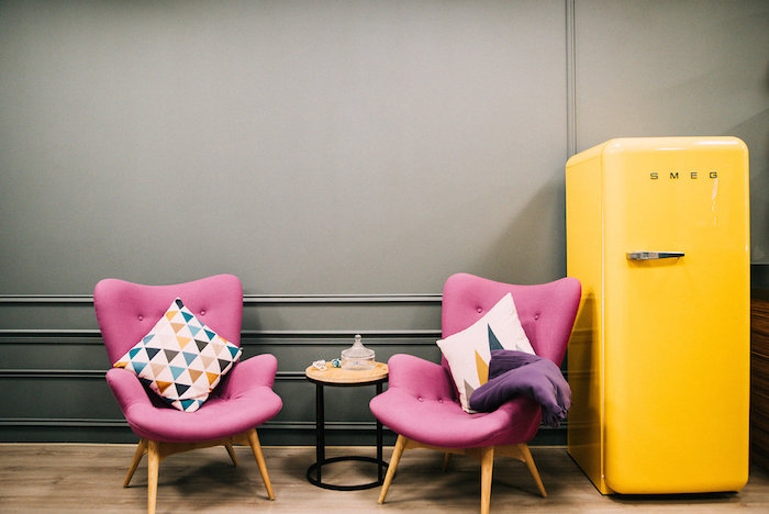 Pink chairs and a yellow SMEG fridge in a pantry