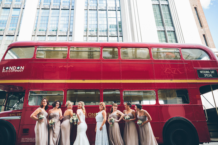 bride and bridesmaid posing in front of london bus