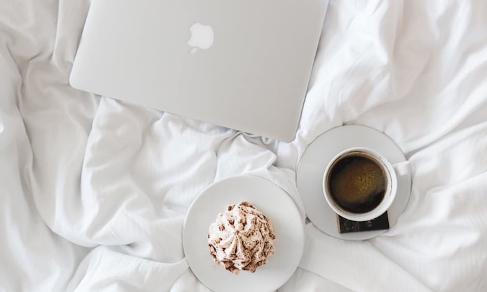 laptop on bed with coffee