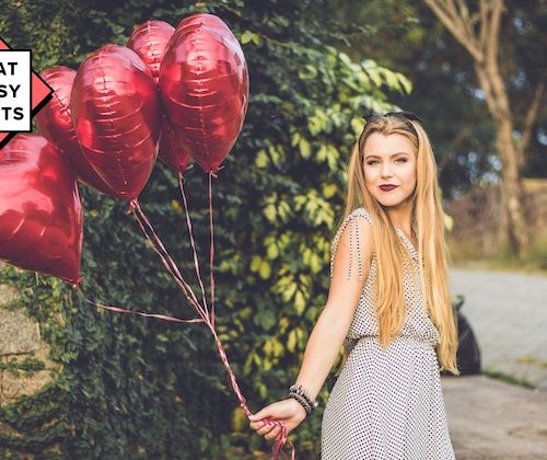 girl holding heart shaped balloons
