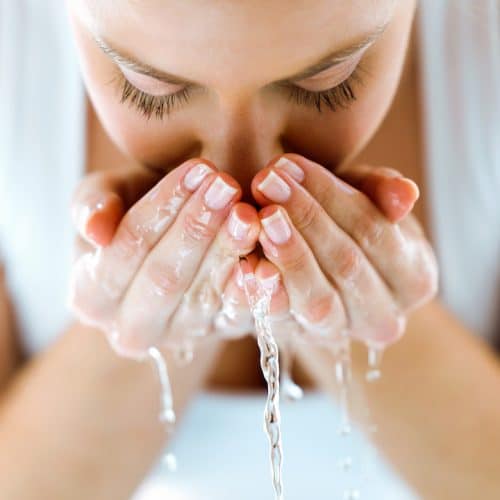 Girl washing face with splashing water