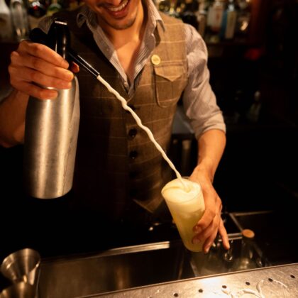 New Drinks Menus This April 2025 featuring The Wise King's mixologist creating a cocktail