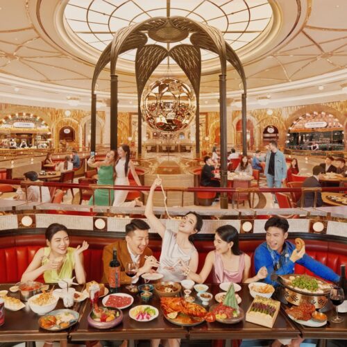 The Grand Opening of Gourmet Pavilion at Wynn Resorts Macau featuring a group of friends at a table with a spread of Asian cuisines from the food hall