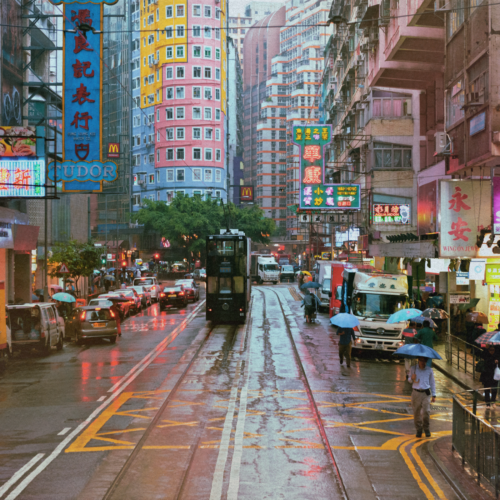 rainy street in hong kong with people carrying umbrellas