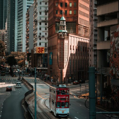 Iconic Hong Kong Tram on Urban Street, with a historic red-bricked church in the background