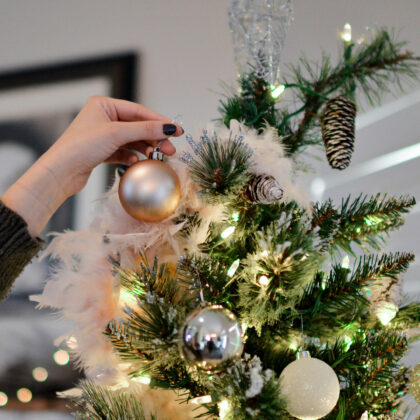 Hand putting an ornament on a Christmas Tree, decorating Xmas tree in Hong Kong in 2026