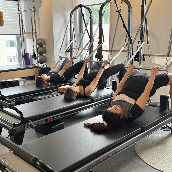  three women in a pilates class at koze pilates, pilates studio in causeway bay tin hau hong kong