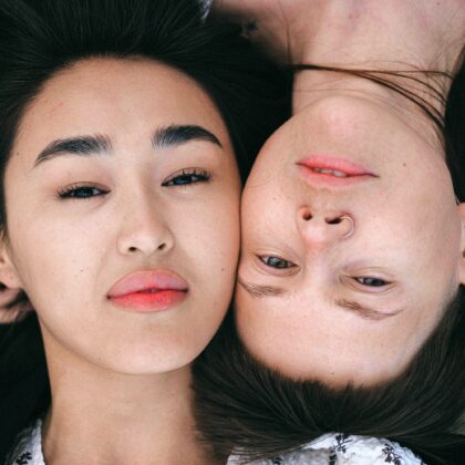 two girls laying next to each other with freshly plucked and waxed eyebrows, representing eyebrow services in hong kong