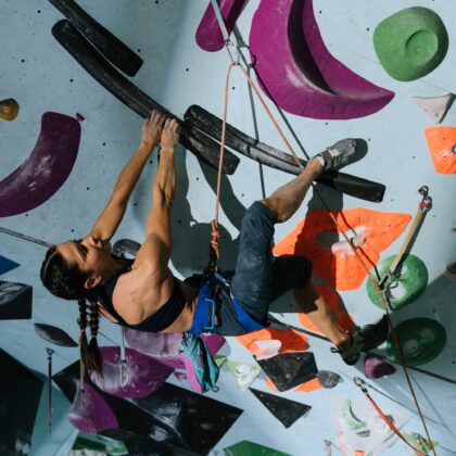 woman rock climbing in an indoor bouldering gym in hong kong