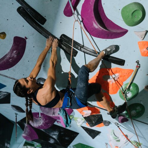 woman rock climbing in an indoor bouldering gym in hong kong