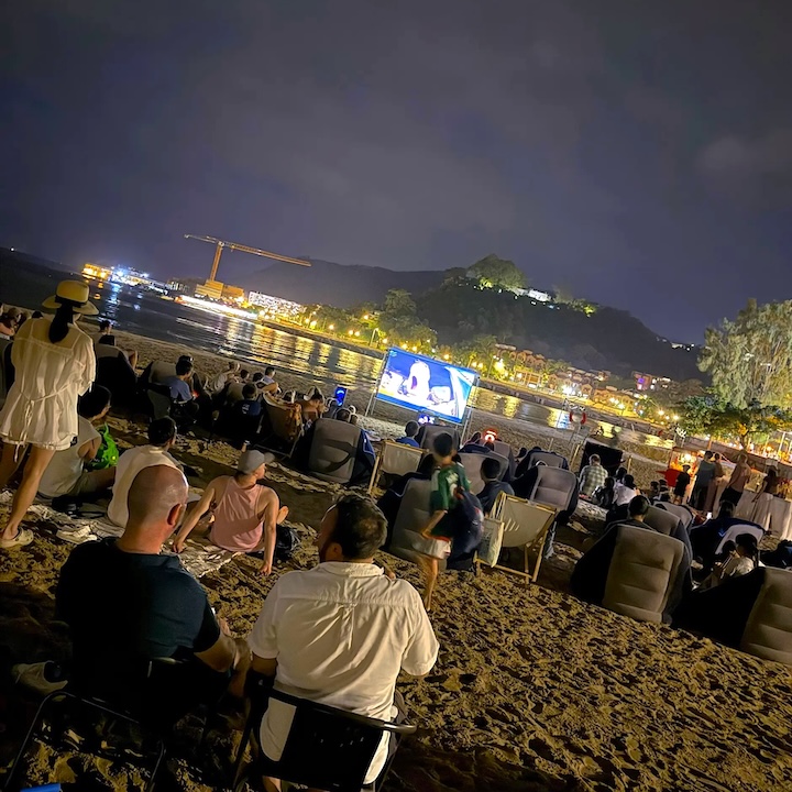 group of people watching a movie screening for Mid-Autumn festival on a Mui Wo beach in Lantau, Hong Kong