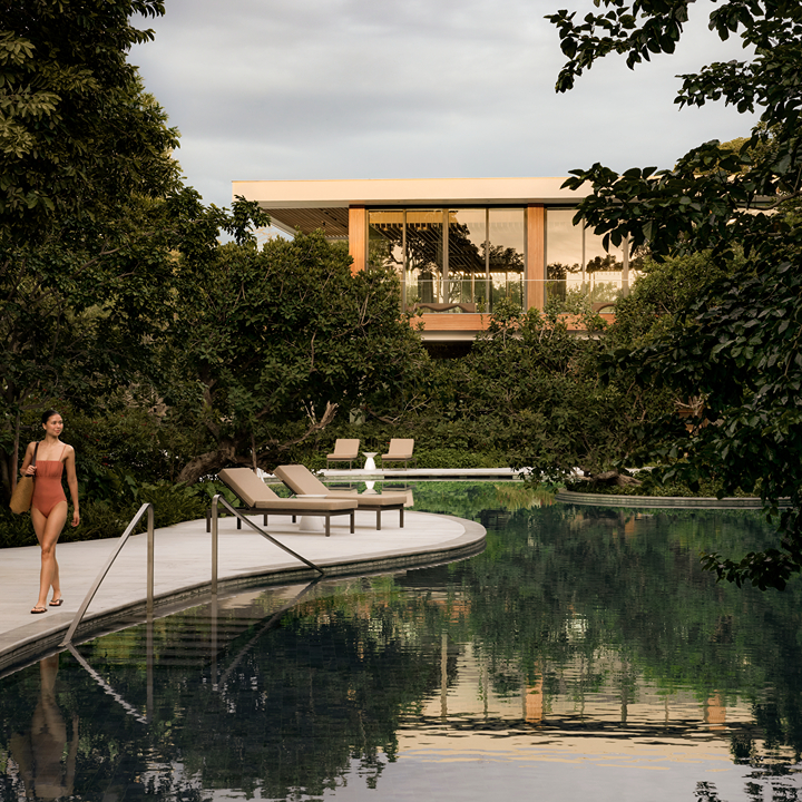 woman walking past the outdoor pool at THE BARAI HUA HIN luxury resort in Thailand