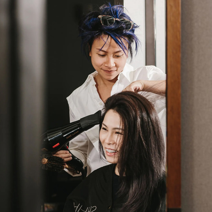 Marvin Lin blowdrying client's hair at SHHH Salon in central during a hair spa treatment