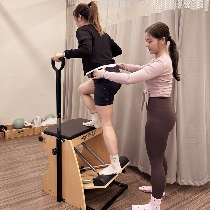 Physiotherapist working with a client on dedicated equipment at Latte Pilates & Physiotherapy's studio in Sheung Wan, Hong Kong